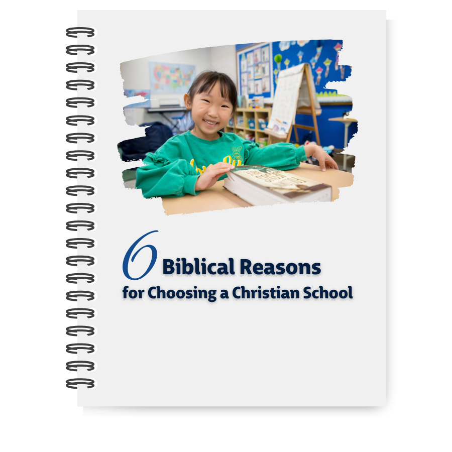 Biblical Reasons for Choosing a Christian School cover photo with young girl at desk smiling and reading open Bible